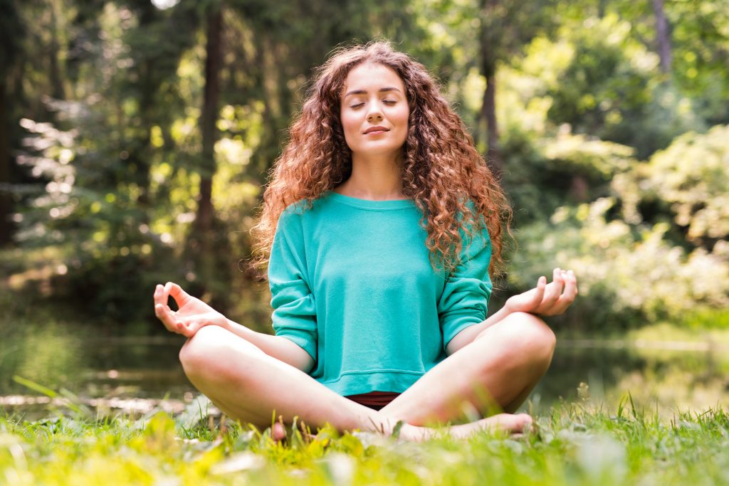 Empowering Teens to Take Charge of Their Own Lives. Teen meditating at the park.